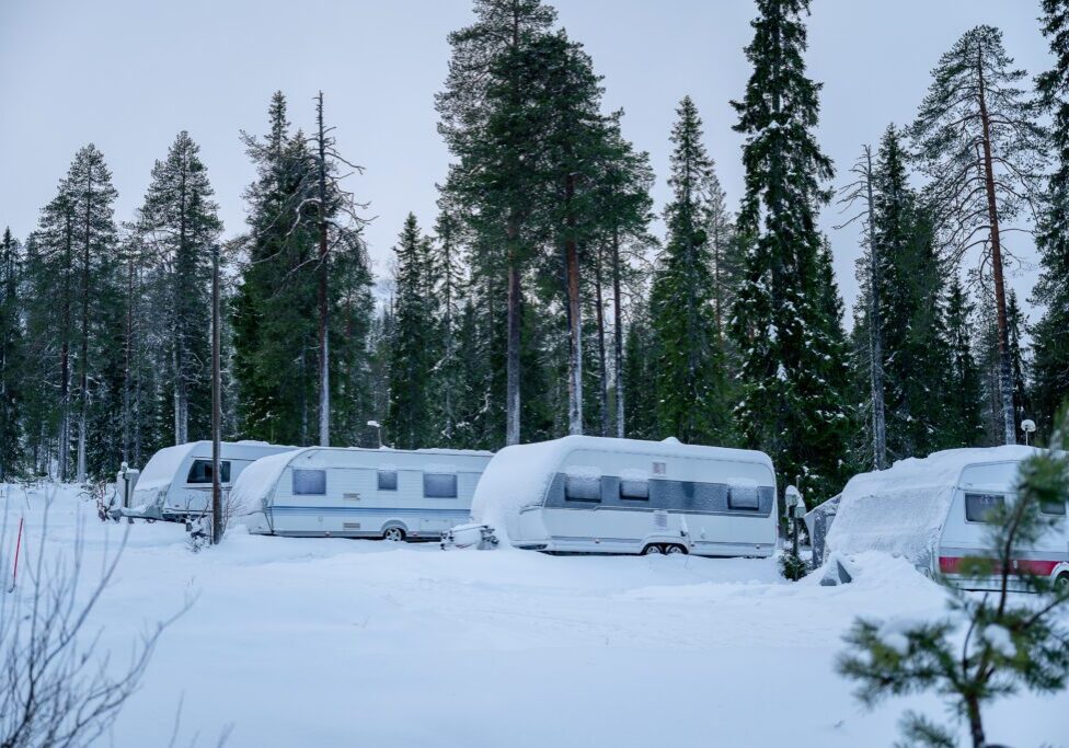 Caravan of camper cars in winter forest. Camping in Lapland Finland. Winter camping concept